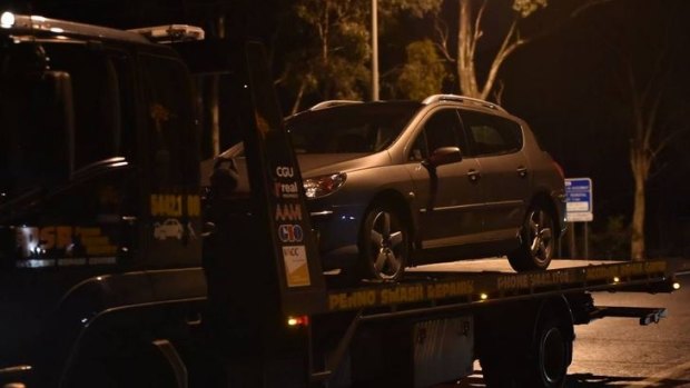 The Peugeot, in which the teenager was found, is towed from the scene.