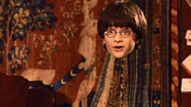 Harry Potter wears his invisible cloak in a screengrab from the popular movie series.