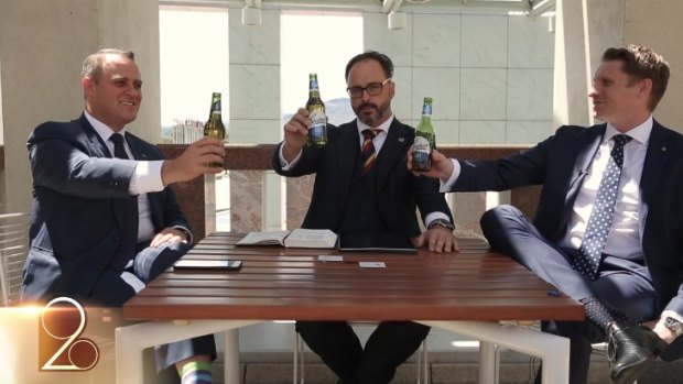 Liberal MPs Tim Wilson, left, and Andrew Hastie, right, hold up Coopers beer bottles in the video.
