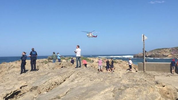 Witnesses look on as an Air Ambulance searches for the men.