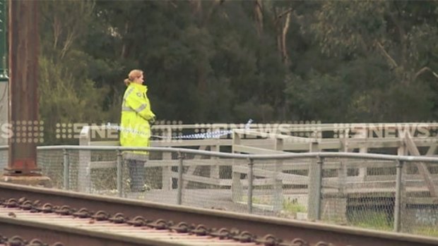 A police officer overlooking the creek at Mooroolbark, near the railway line.
