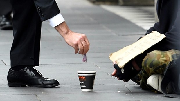 Malcolm Turnbull gives $5 to a homeless man in Melbourne.