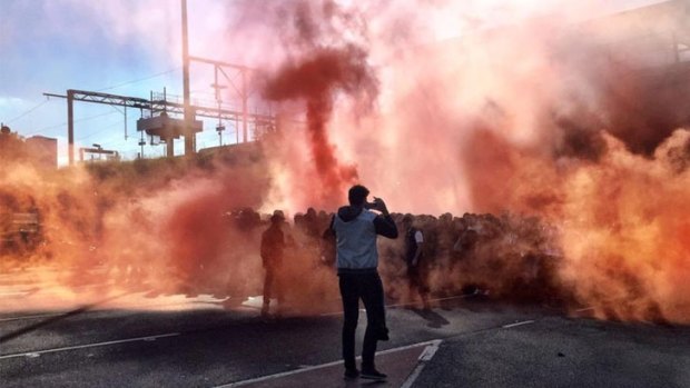 Members of Melbourne Victory's North Terrace fan group set off flares before the game.
