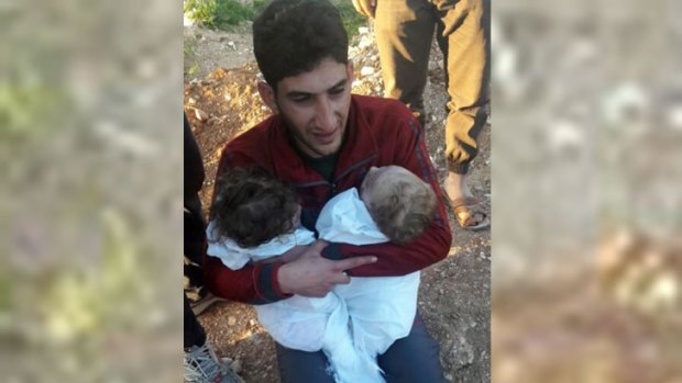 A man holds his twin babies who were killed during the chemical weapons attack in Syria.