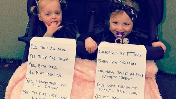 Annie Nolan's twin daughters, Delphine and Cheska, with the two signs.