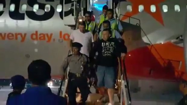 The men being escorted from the Jetstar plane in Bali.