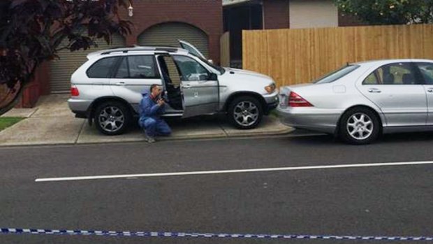  Police investigate damaged cars at the scene of the shooting of the Ahmad family home in Lalor. 