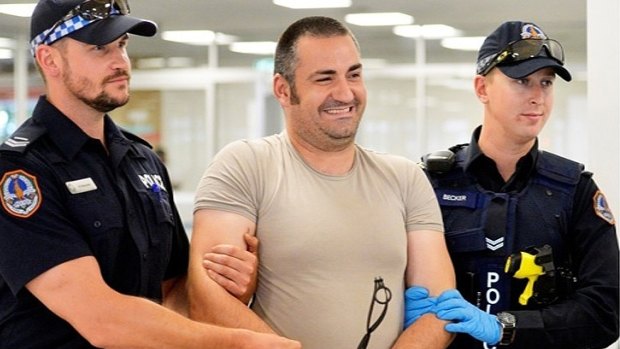 Aniello Vinciguerra is walked through Darwin Airport by two police officers after his arrest in December, 2014.