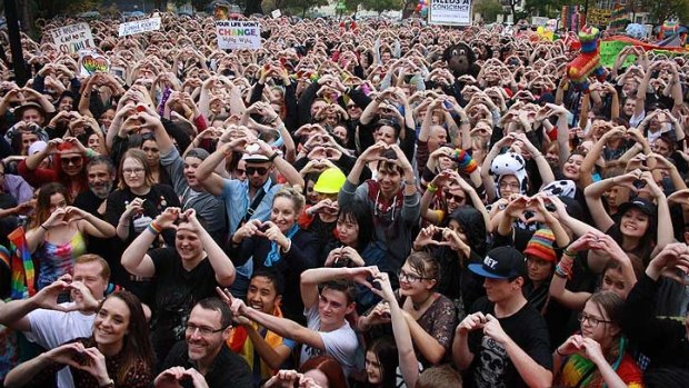 Supporters at the 'Love Rally' in Perth create hearts with their hands.