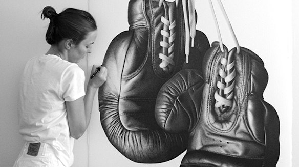 CJ Hendry puts the finishes touches to a pair of boxing gloves that attracted the attention of world champion pugilist Floyd Mayweather.