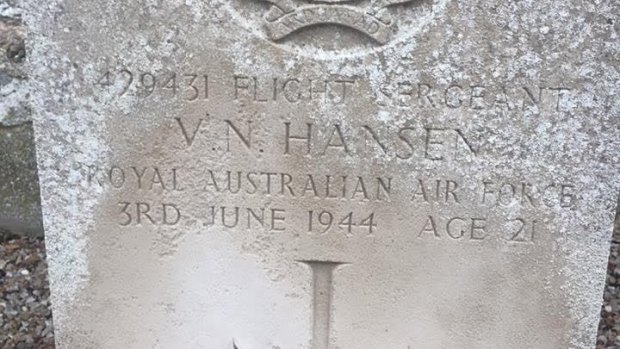Flowers are laid at Vernon Hansen's grave, yet his family may have no idea he is buried in France.