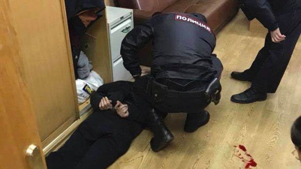 Police officers detain the unidentified man in the offices of the Echo of Moscow radio station.