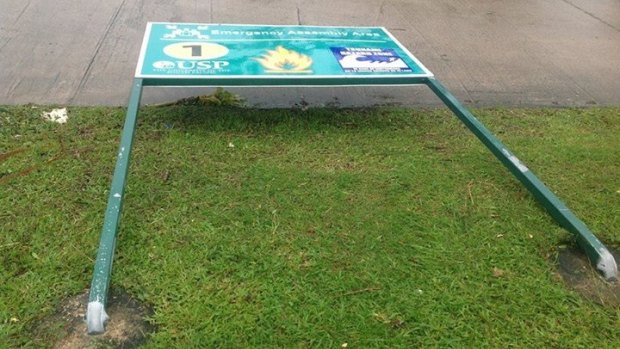 A University of South Pacific sign bent by the ferocity of Cyclone Pam.