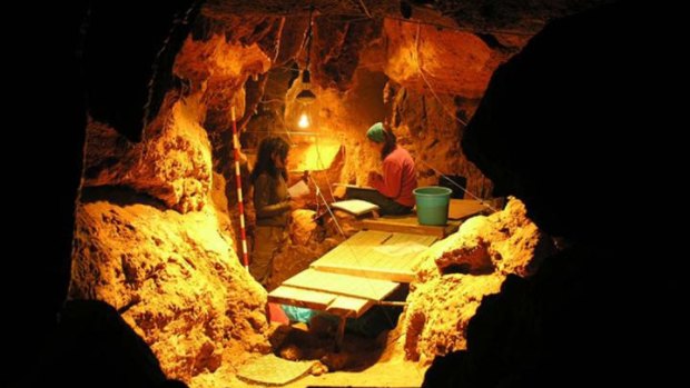 Scientists work in a cave, where 12 Neanderthal specimens were found. 