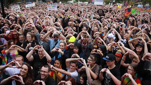 Supporters at the 'Love Rally' in Perth create hearts with their hands.