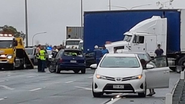 A truck jack-knifed on the M1 Motorway, with several cars damaged and traffic building.