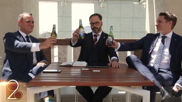 Liberal MPs Tim Wilson, left, and Andrew Hastie, right, hold up Coopers beer bottles in the video.