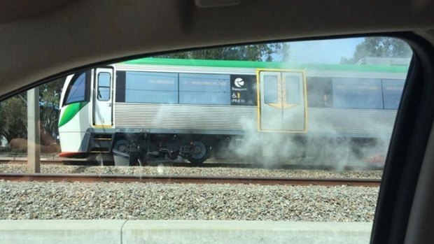 Smoke billows from beneath the train.