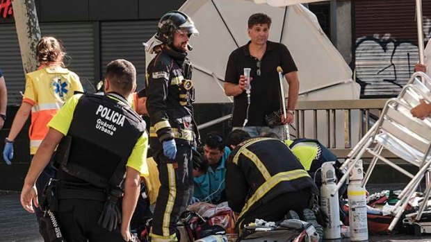 Paramedics tend to a pedestrian struck by a van driving through crowds on Las Ramblas, Barcelona's most famous street, killing at least 13, on August 17.