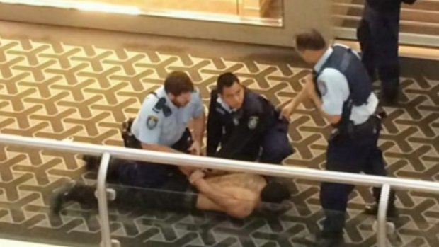Restrained: Police subdue the attacker after the stabbing death at Westfield Parramatta.