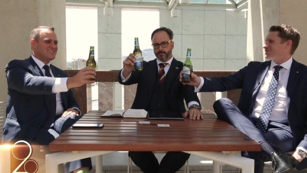 Liberal MPs Tim Wilson, left, and Andrew Hastie, right, hold up Coopers beer bottles in the video.