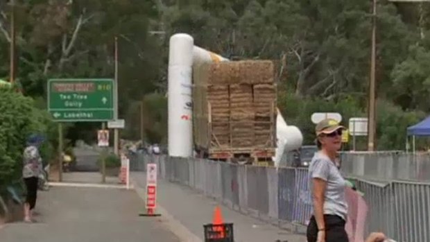 A truck laden with hay drags away the finish line of the Tour Down Under.