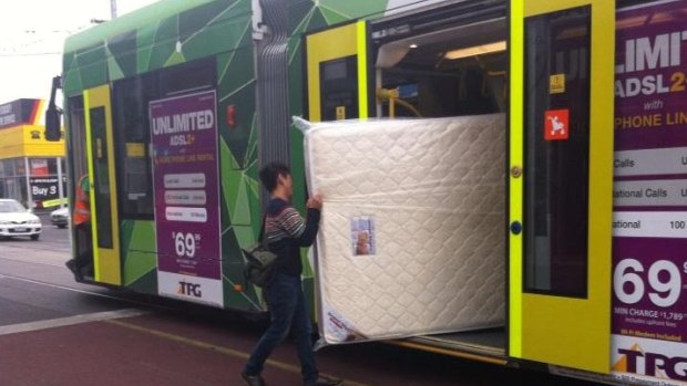 A new mattress heads to its new home via public transport in Melbourne.