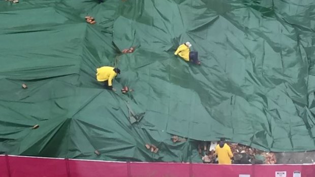 Workers at the Carlton site put tarpaulins over the remains of the pub. 