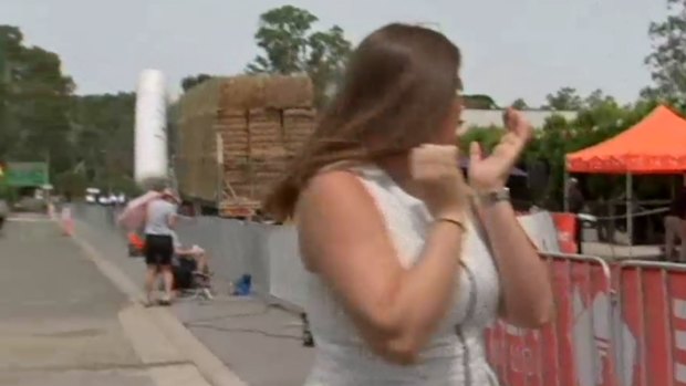 Reporter Sarah Hancock turns around as the truck begins to drag the inflatable structure.