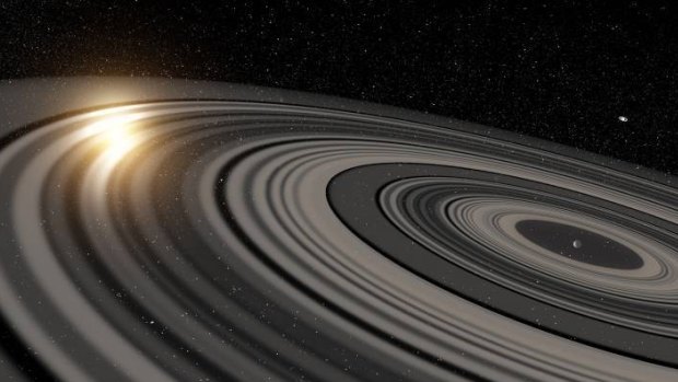 An artist impression of the extrasolar ring system around the young giant planet or brown dwarf J1407b. Saturn is seen on the top right.
