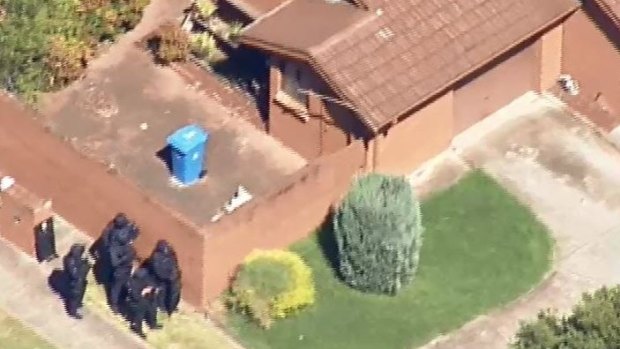 Heavily-armed police outside the Dandenong North property in March.