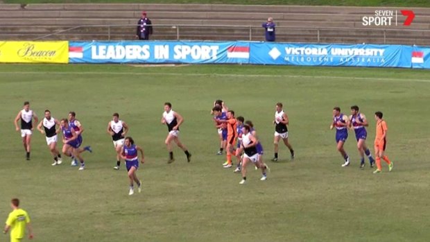 Western Bulldogs ruckman Will Minson (centre, next to umpire in orange) was sent off for making contact with an umpire.
