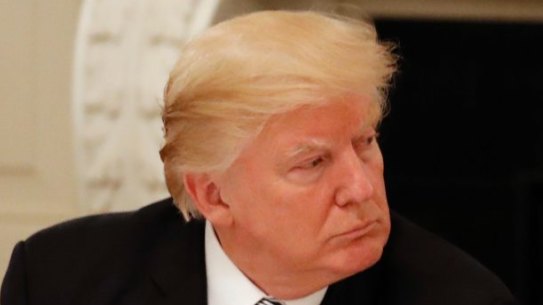 Not much love lost: Donald Trump (with Microsoft CEO Satya Nadella in the centre) listens to Amazon boss Jeff Bezos during an American Technology Council roundtable at the White House in June.