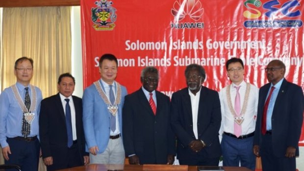 Solomon Islands Prime Minister Sogavare (centre) flanked by ministers and Huawei officials at a signing ceremony.