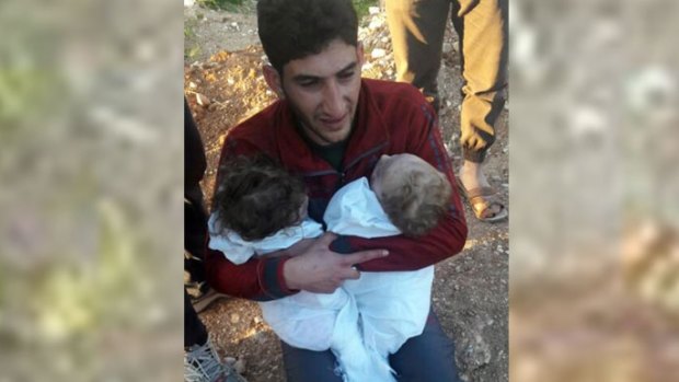 A man holds his twin babies who were killed during the chemical weapons attack in Syria.