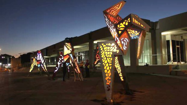 The Origami Horses  lit up at night in West Ryde plaza.