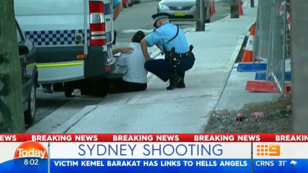 A distressed man at the scene of Kemel Barakat's shooting is treated by paramedics. 