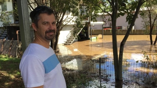 Aaron Bone outside his flooded home at Ipswich.