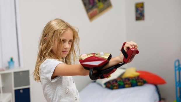 Evangeline Lindes, 8, demonstrates the Playmation “Avengers” glove, which uses a wireless system and sensors to control action figures.