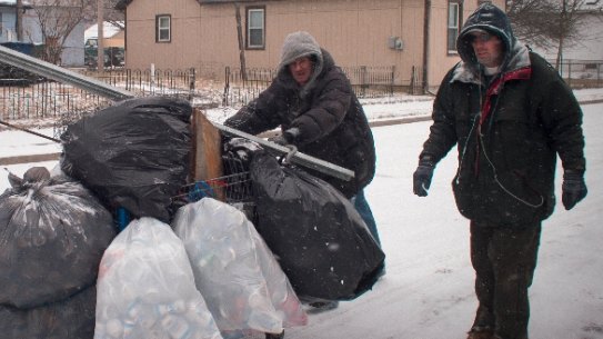 A pair of scrappers fight blizzard conditions to deliver their haul of aluminium cans to the scrapyard. They may earn $30 to $50 for the lot.
