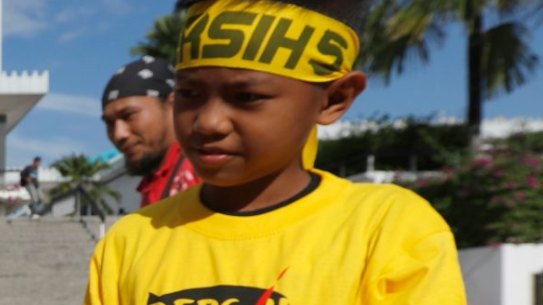 Protesters sell "Bersih" T-shirts outside a national mosque during the rally in Kuala Lumpur, on Saturday.