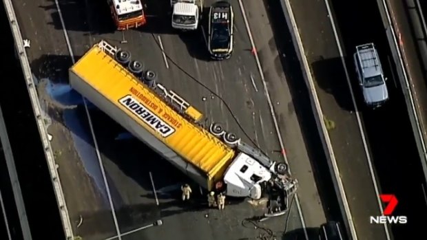 A semi-trailer has been lying on its side on the Western Ring Road in Glenroy for two hours after rolling at 10.30am.