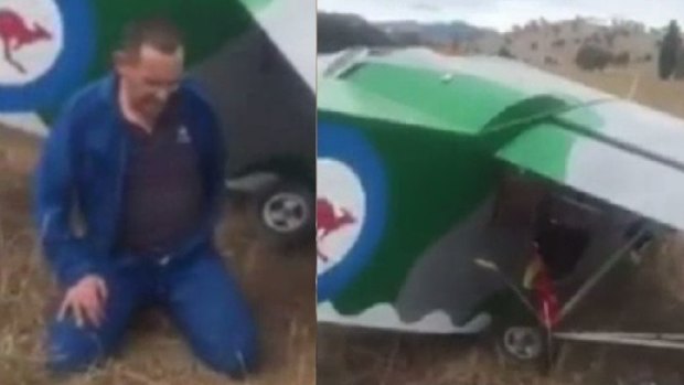 A man sits in shock after crash landing in a paddock, near Tumut.