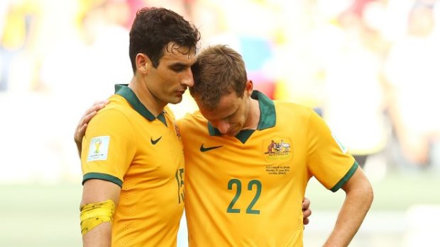 Disappointed ... Socceroos captain Mile Jedinak shares a moment with Alex Wilkinson after Spain's 3-0 win.