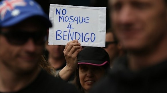 A woman holds a sign during an anti-mosque rally in August 2015.