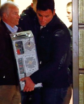 Police carry a computer out of Andreas Lubitz's house.