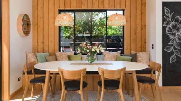 This dining area features a wooden feature wall that blends into the booth dining seat.