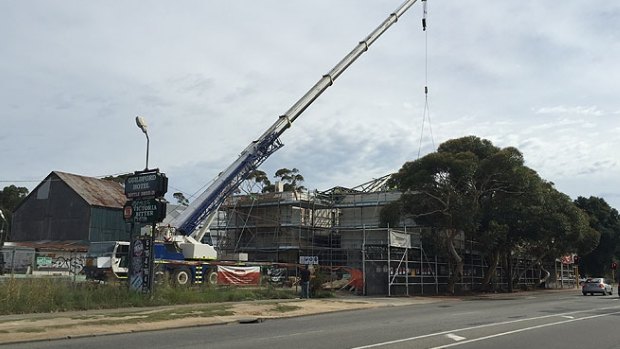 Cranes help place the finishing touches on the roof of the Guildford hotel