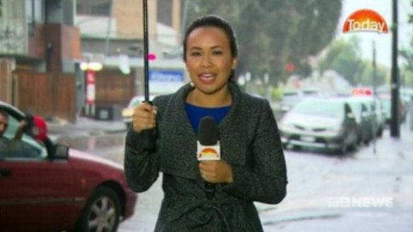 A man believed to be James Gargasoulas waves his hat behind a camera crew.  