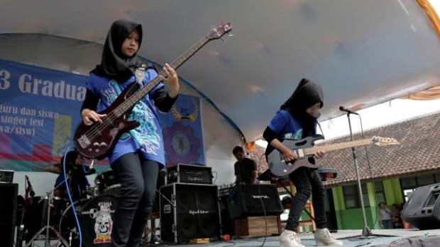 Widi Rahmawati (L) and Firdda Kurnia, members of the metal band Voice of Baceprot, perform during a school's farewell event in Garut, Indonesia, May 15, 2017. 